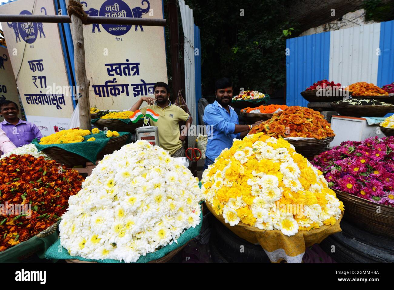 Venditore di fiori nel mercato colorato a Pune, India. Foto Stock