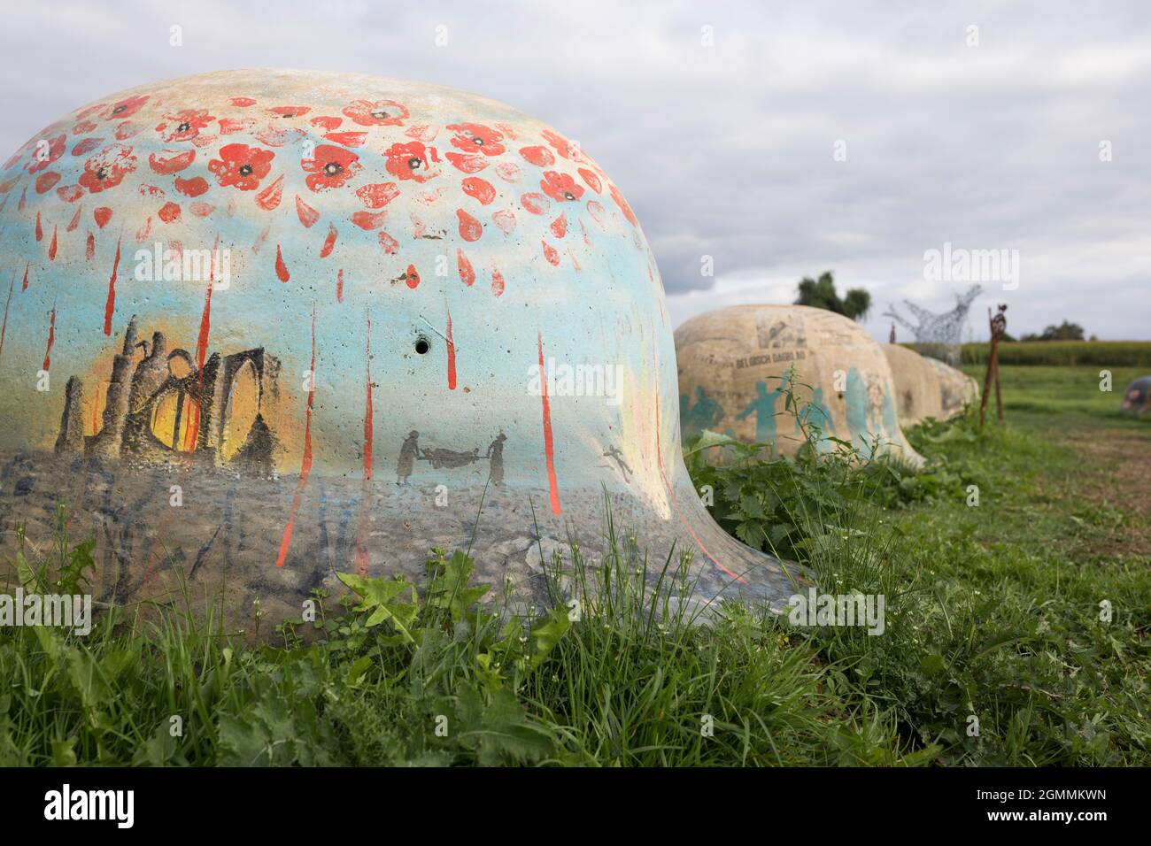 Monumento commemorativo della prima Guerra Mondiale con 44 caschi in cemento in un paesaggio in Belgio Foto Stock