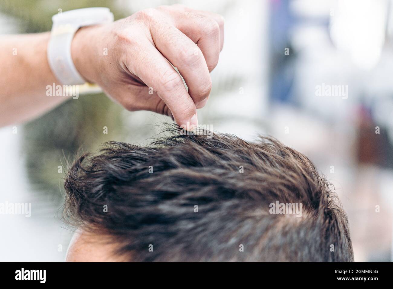 Barber fissare i capelli di un cliente con gel per capelli Foto Stock