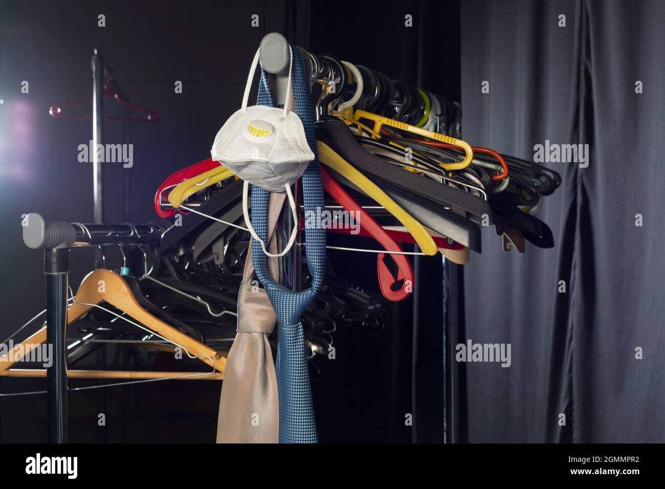 Maschera facciale, cravatte e appendiabiti su rack Foto Stock