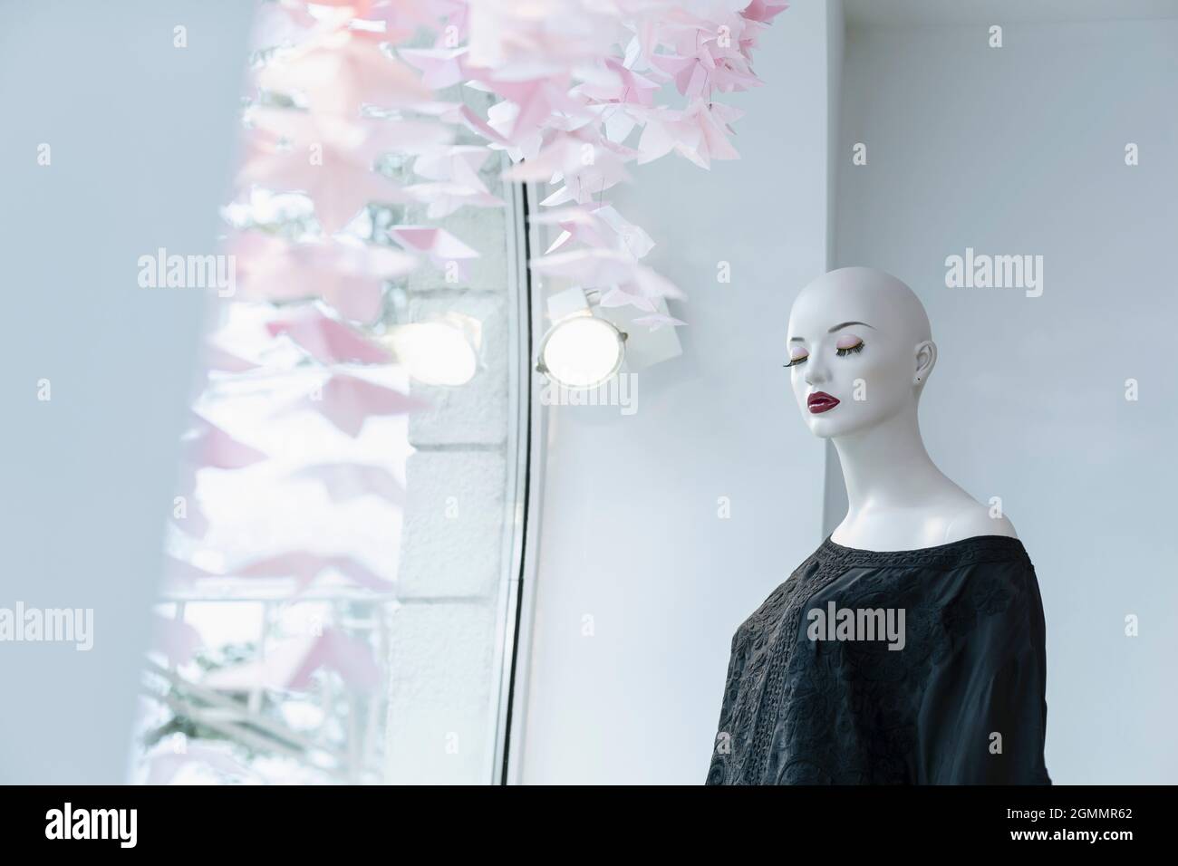 Manichino con gli occhi chiusi in una finestra boutique Foto Stock