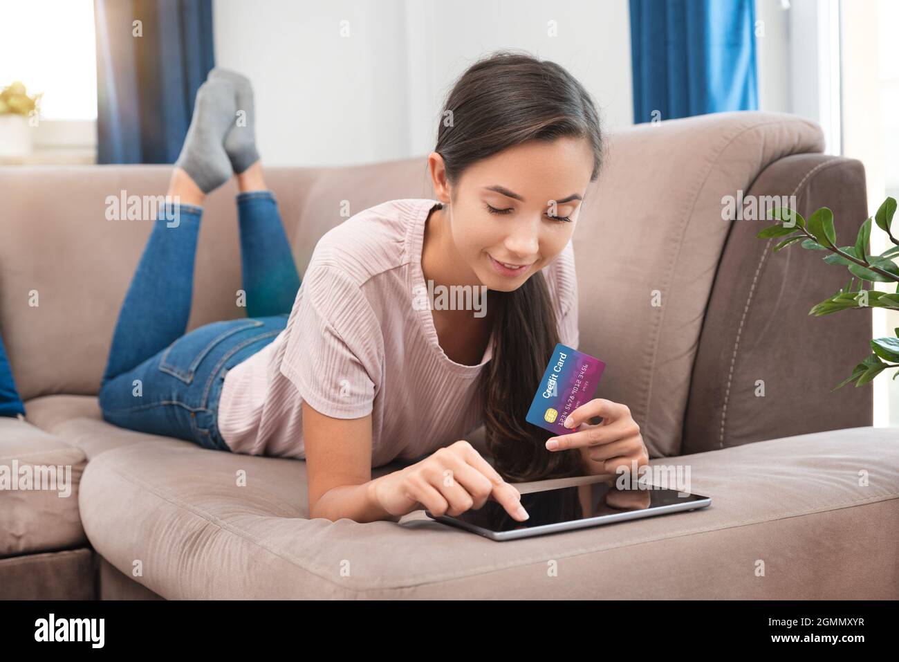 Donna che fa shopping in internet con tablet, utilizzando la carta di credito Foto Stock