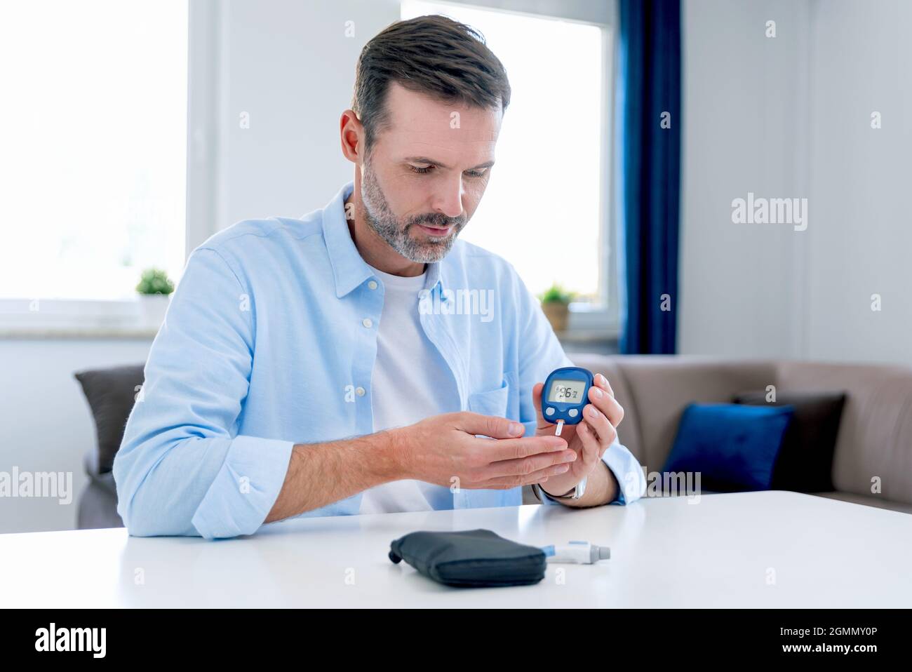 L'uomo misura il suo zucchero nel sangue. Glucometro, analisi del campione di sangue, concetto di diabete. Foto Stock