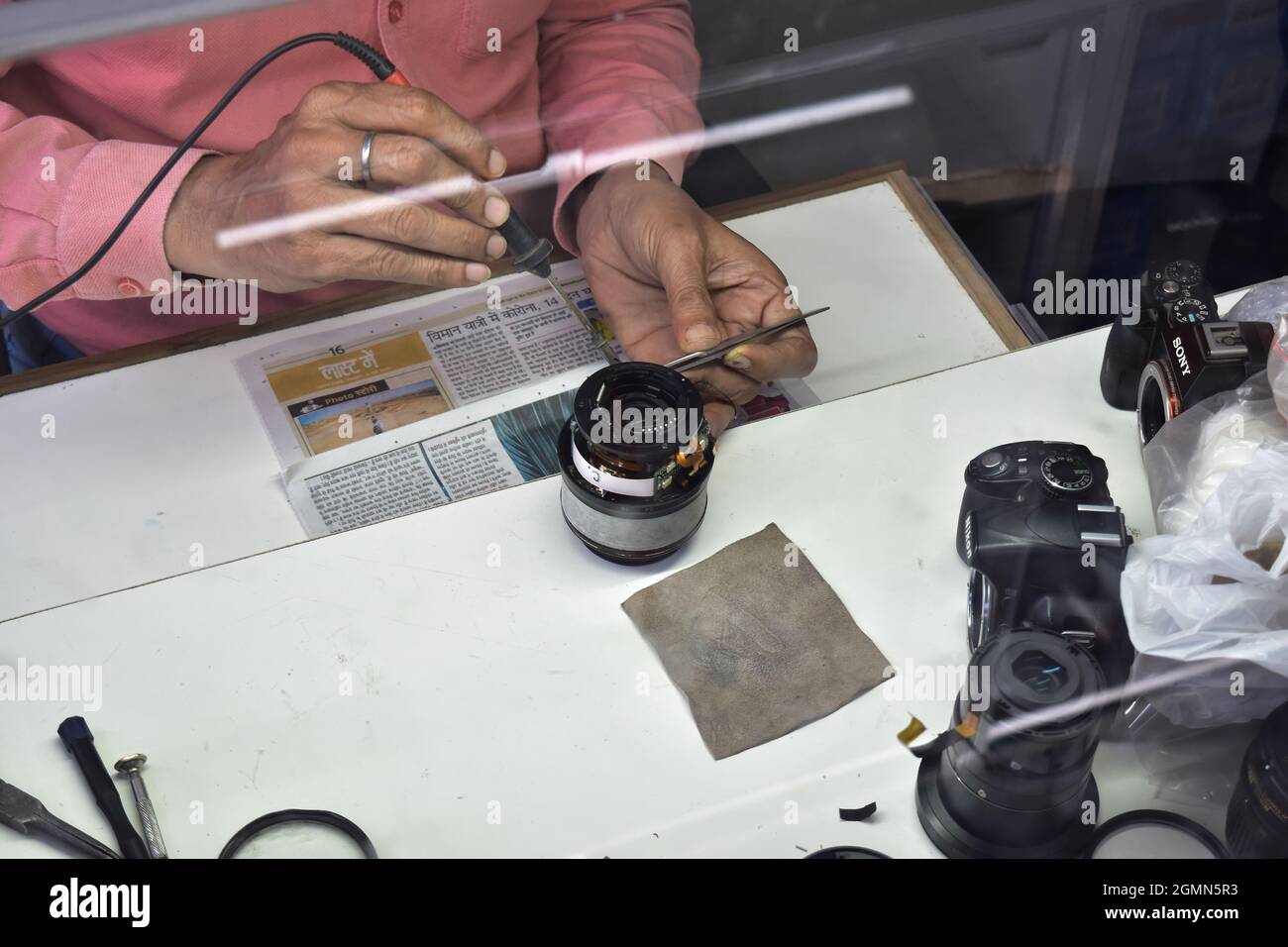 Tecnico Riparazione lenti telecamera presso il punto di riparazione Foto Stock