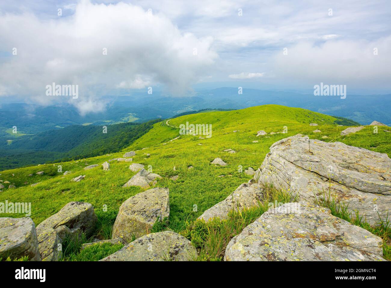 vista dalla montagna runa. enormi pietre sulle pendici erbose. paesaggio estivo dei monti carpazi. bieszczady e cresta vihorlat in lontananza ben Foto Stock