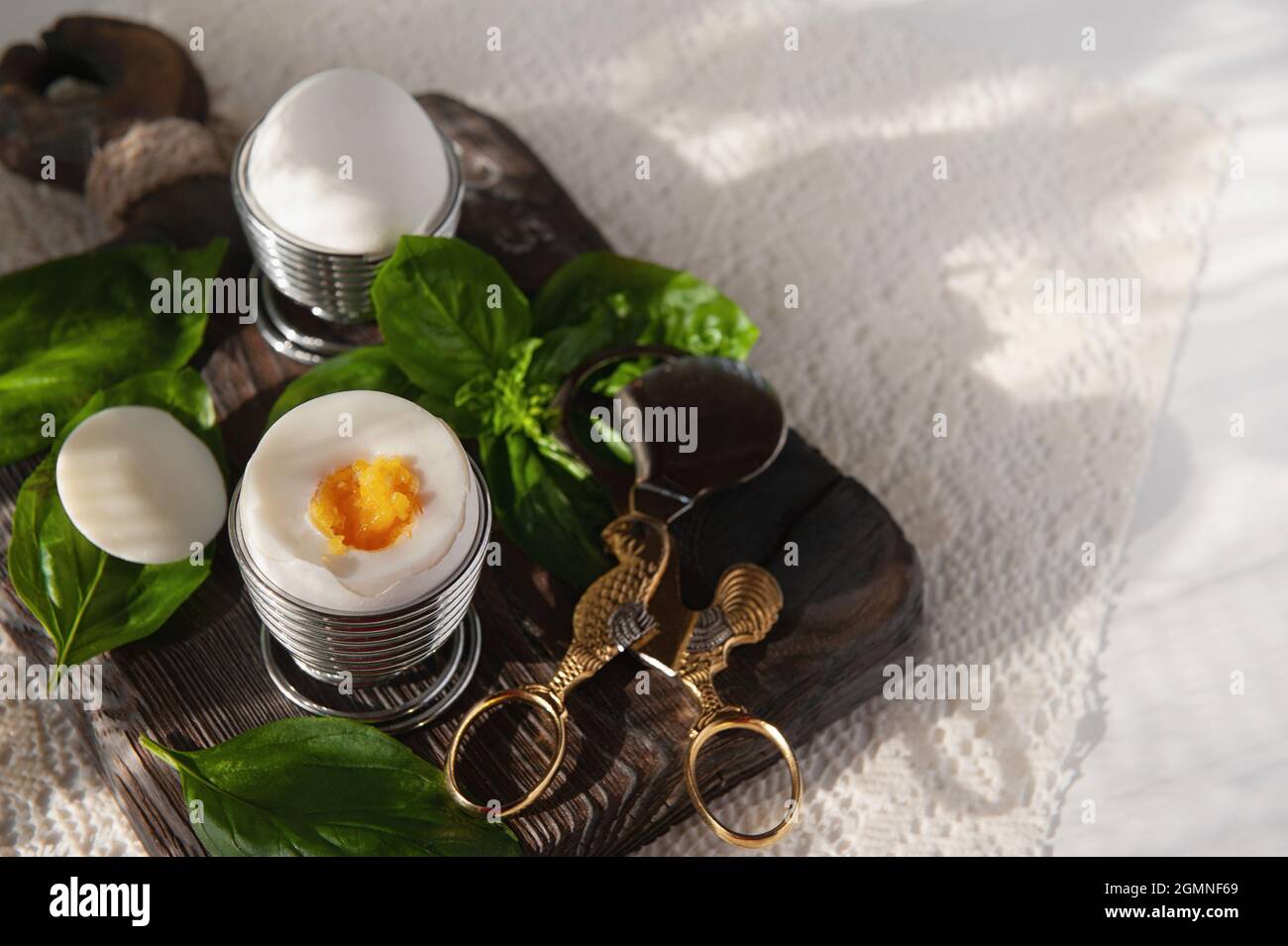 Aprire un uovo sodo in una tazza. Colazione fatta in casa a basso contenuto calorico su un tavolo rustico. Spazio copia. Foto Stock