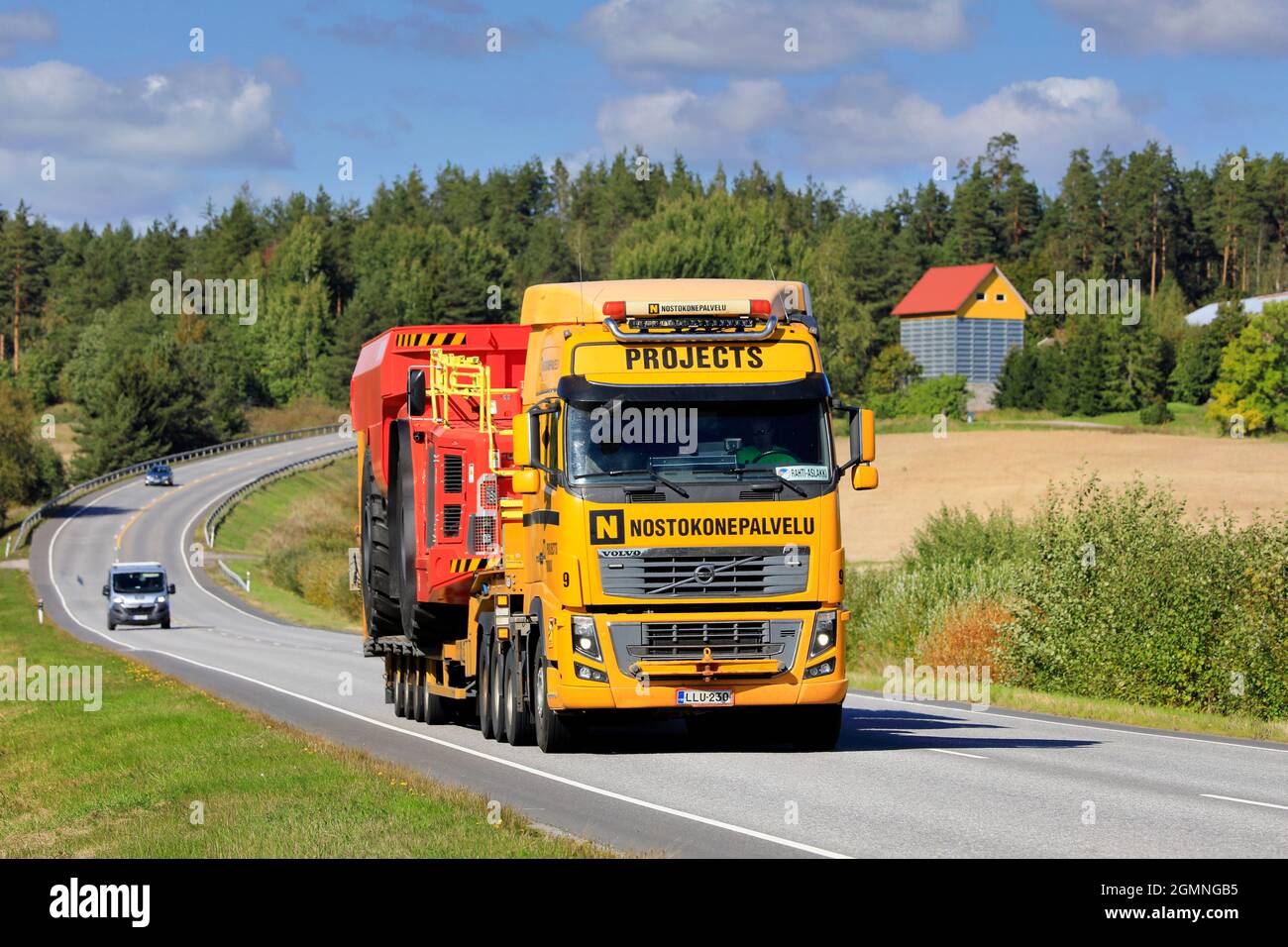 Paesaggio stradale con Volvo FH16 semirimorchio camion Nostokonepalvelu Oy che trasporta il veicolo minerario Sandvik in giorno di sole. Salo, Finlandia. Settembre 10, 2021. Foto Stock