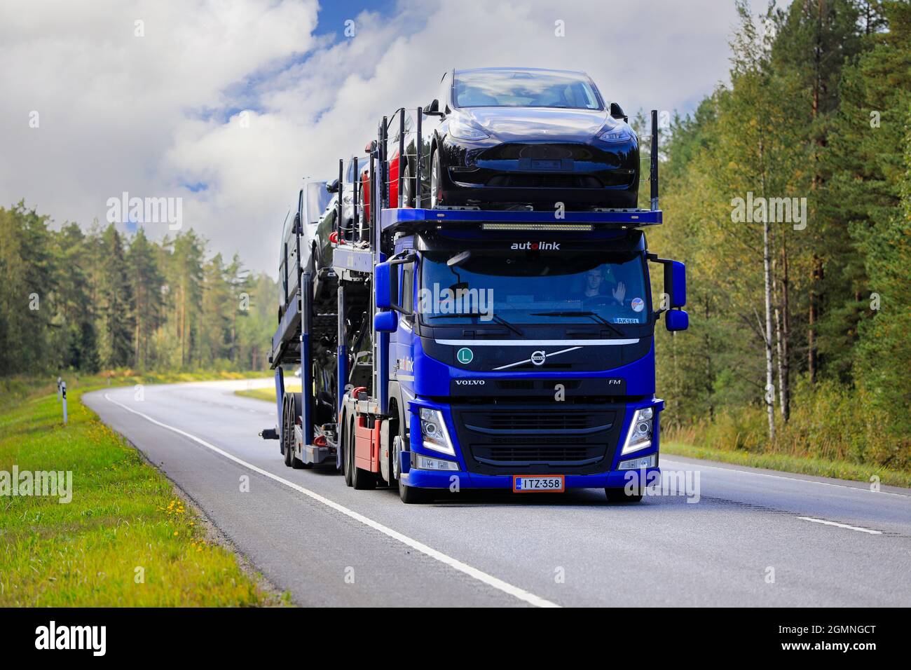 La compagnia aerea Blue Volvo FM Autolink Oy trasporta Tesla e altre auto nuove sulla strada 25 dal porto di Hanko alla terraferma. Raasepori, Finlandia. 9 settembre 2021. Foto Stock