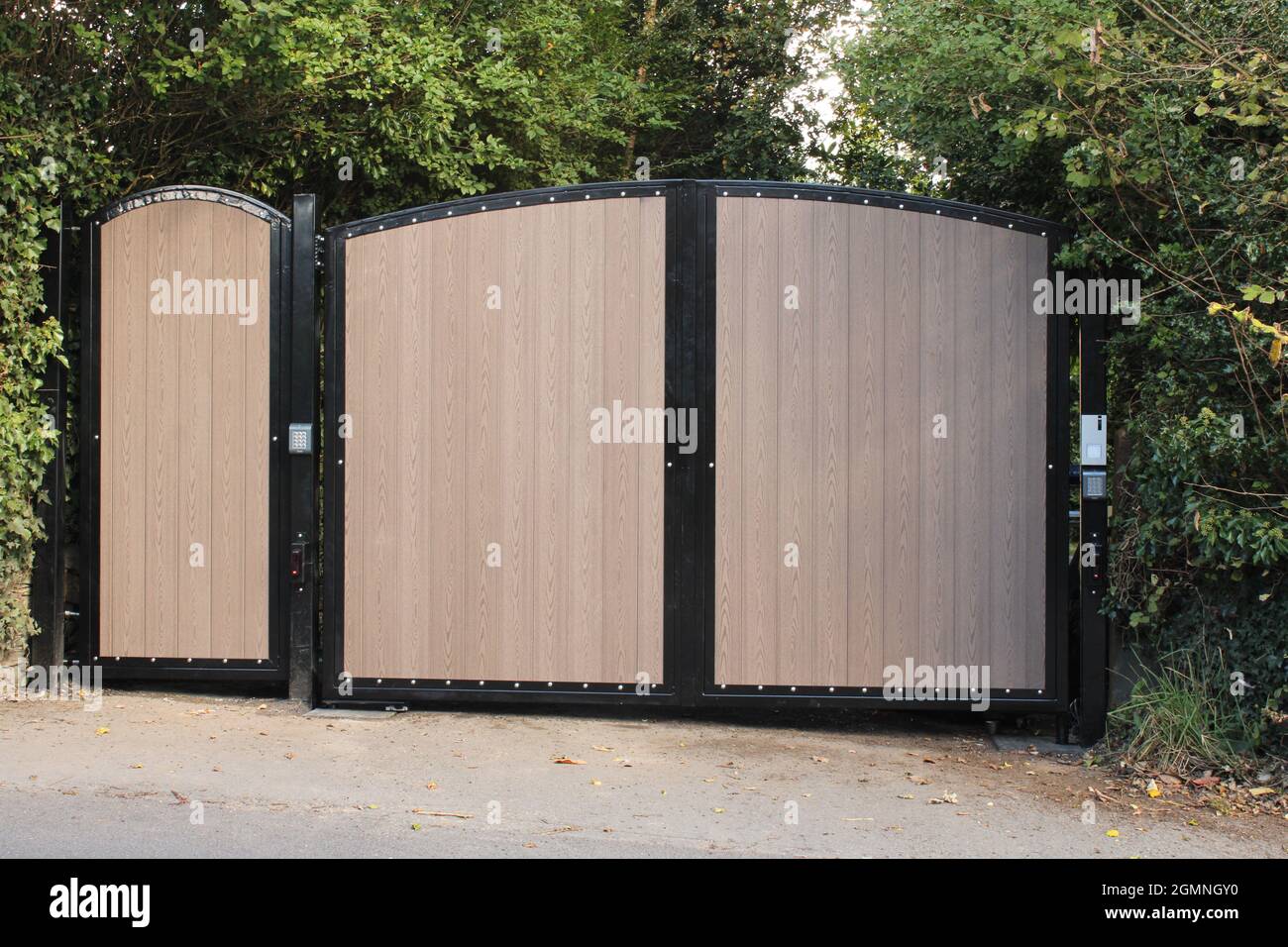Porte di sicurezza elettriche in metallo e legno composito residenziali di recente installazione con tastierini Foto Stock