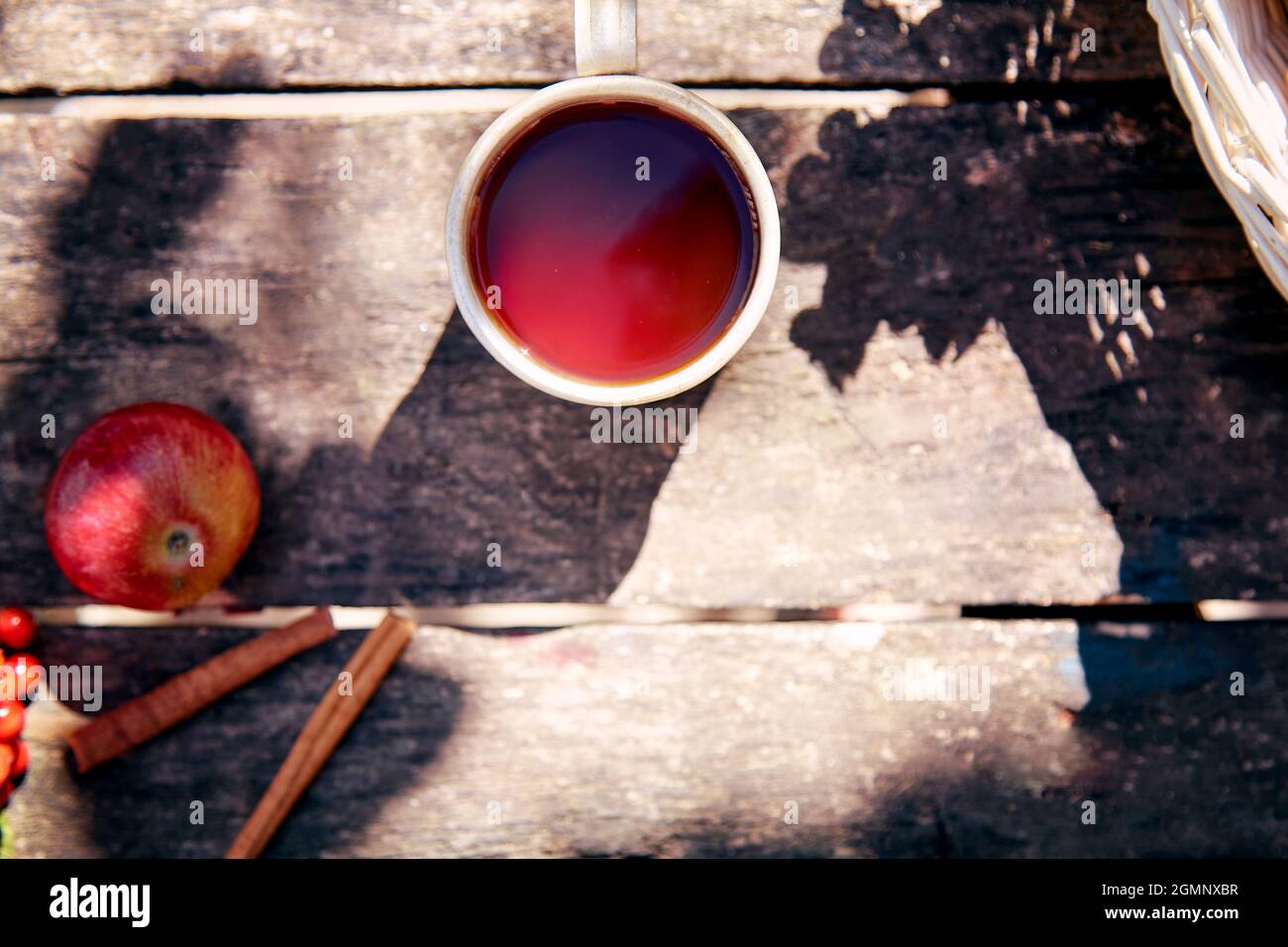 Tazza di tè su sfondo di legno in stile rustico con ombre naturali alla moda. Vista dall'alto. Autunno accogliente estetica natura morta. Stagione calda. Estate indiana Foto Stock