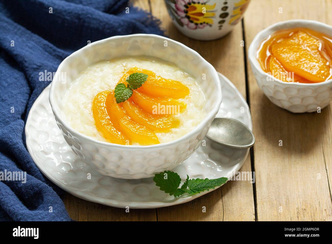 Colazione di porridge di riso con marmellata di pesche e tè. Stile rustico. Foto Stock