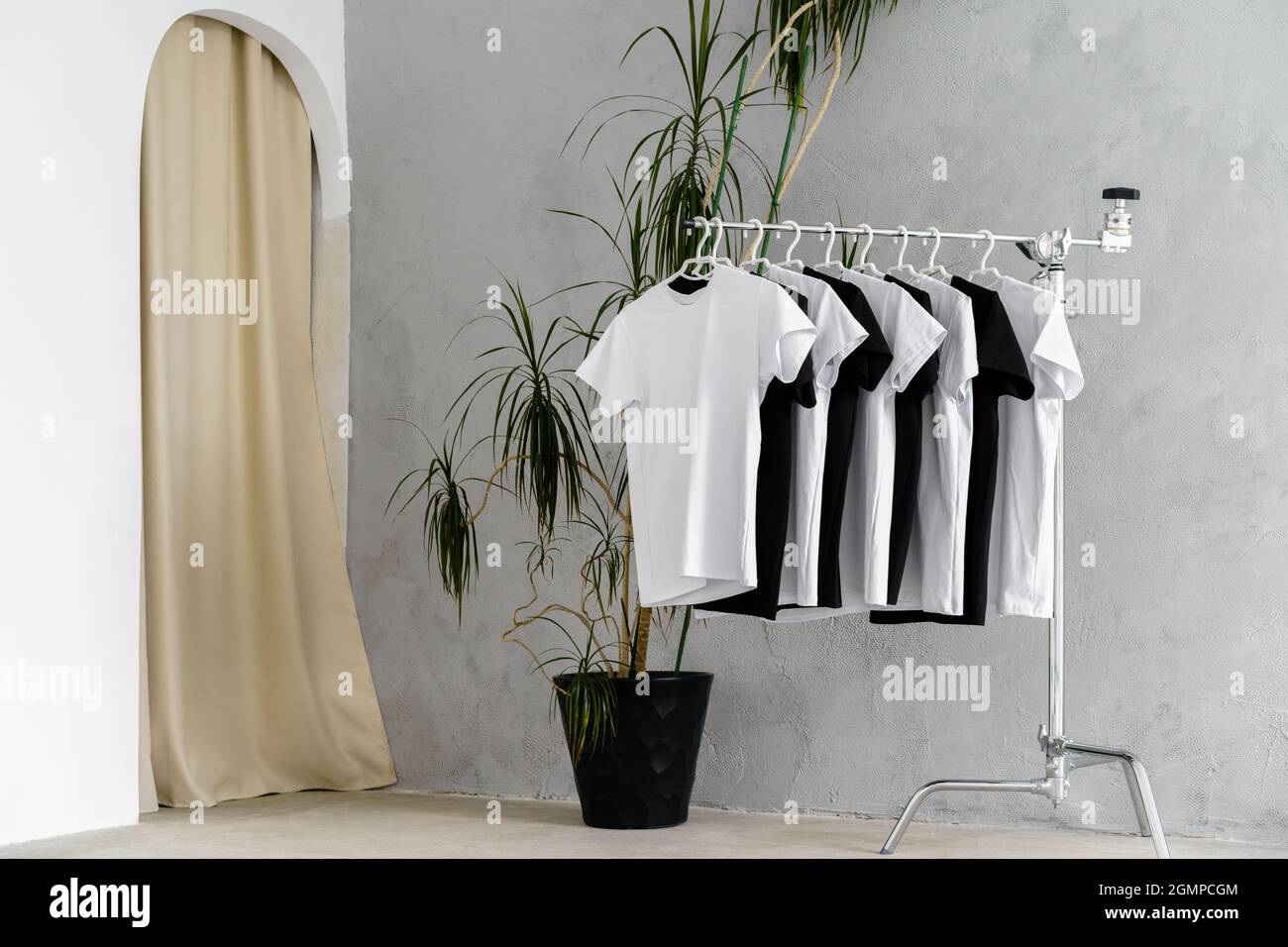 Fila di magliette bianche e nere appese sul rack Foto stock - Alamy