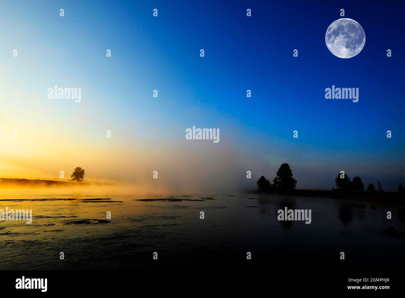 Alba del mattino con alberi e fiume sotto il cielo blu e la nebbia incandescente e luna piena Foto Stock