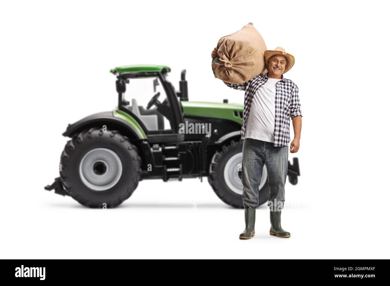Ritratto completo di un agricoltore che porta un sacco e si trova di fronte a un trattore isolato su sfondo bianco Foto Stock