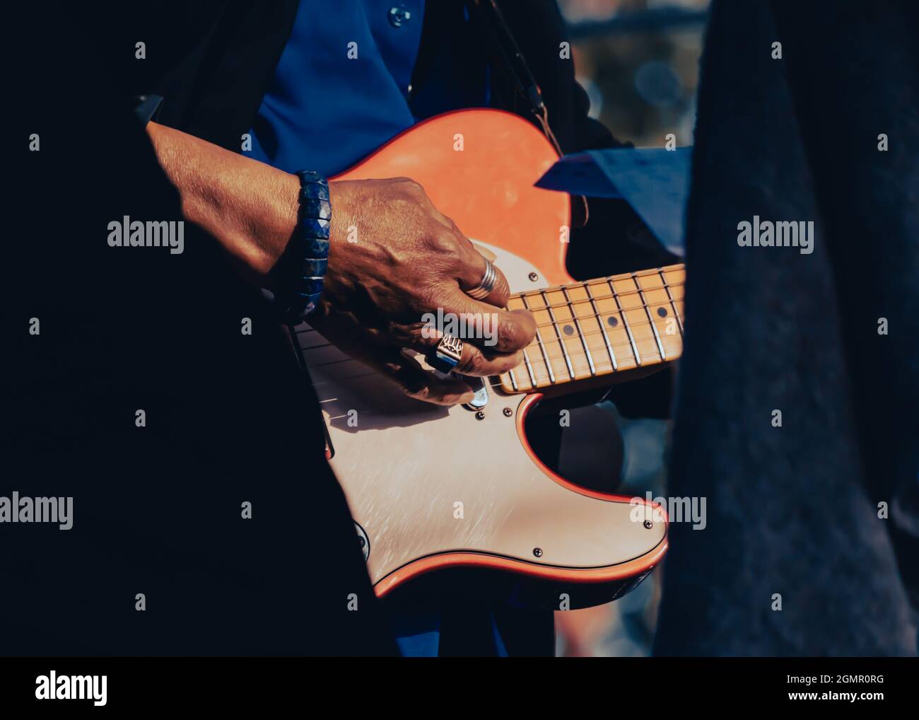 Immagine ravvicinata di una mano di qualcuno di colore che suona una chitarra elettrica Foto Stock