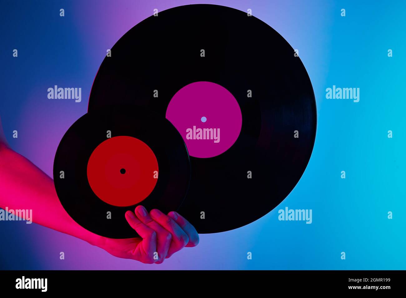 Donna tenere due dischi in vinile retrò in mani, foto tonica. Stile vintage anni '80 e '90 Foto Stock