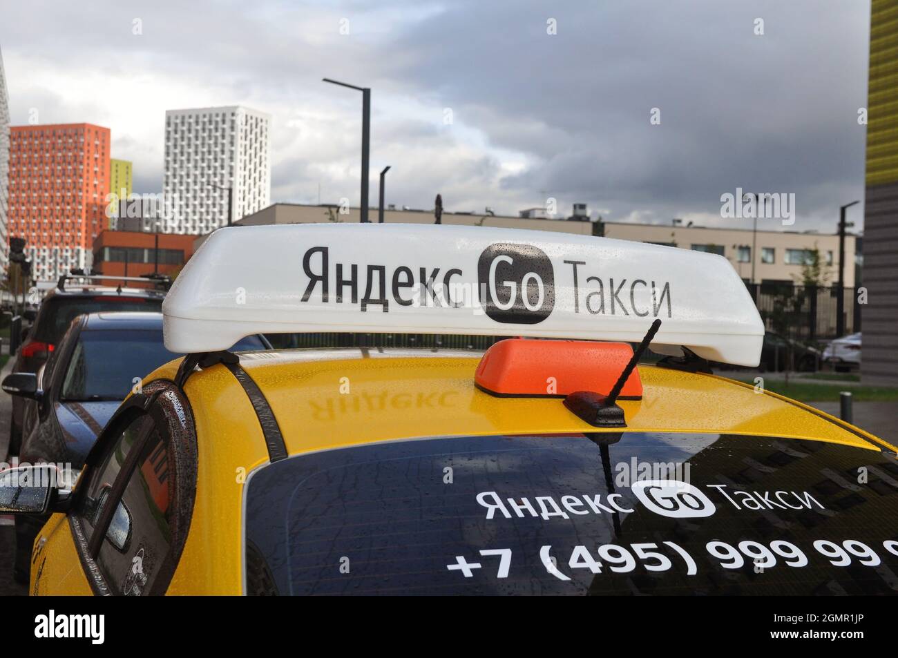 Yandex Taxi sullo sfondo della città. Luci di identificazione sul tetto della vettura con un logo. Primo piano Foto Stock