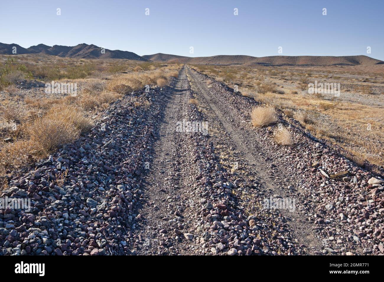 Strada rocciosa del deserto lungo un vecchio grado di ferrovia nel deserto di Mojave della California Foto Stock