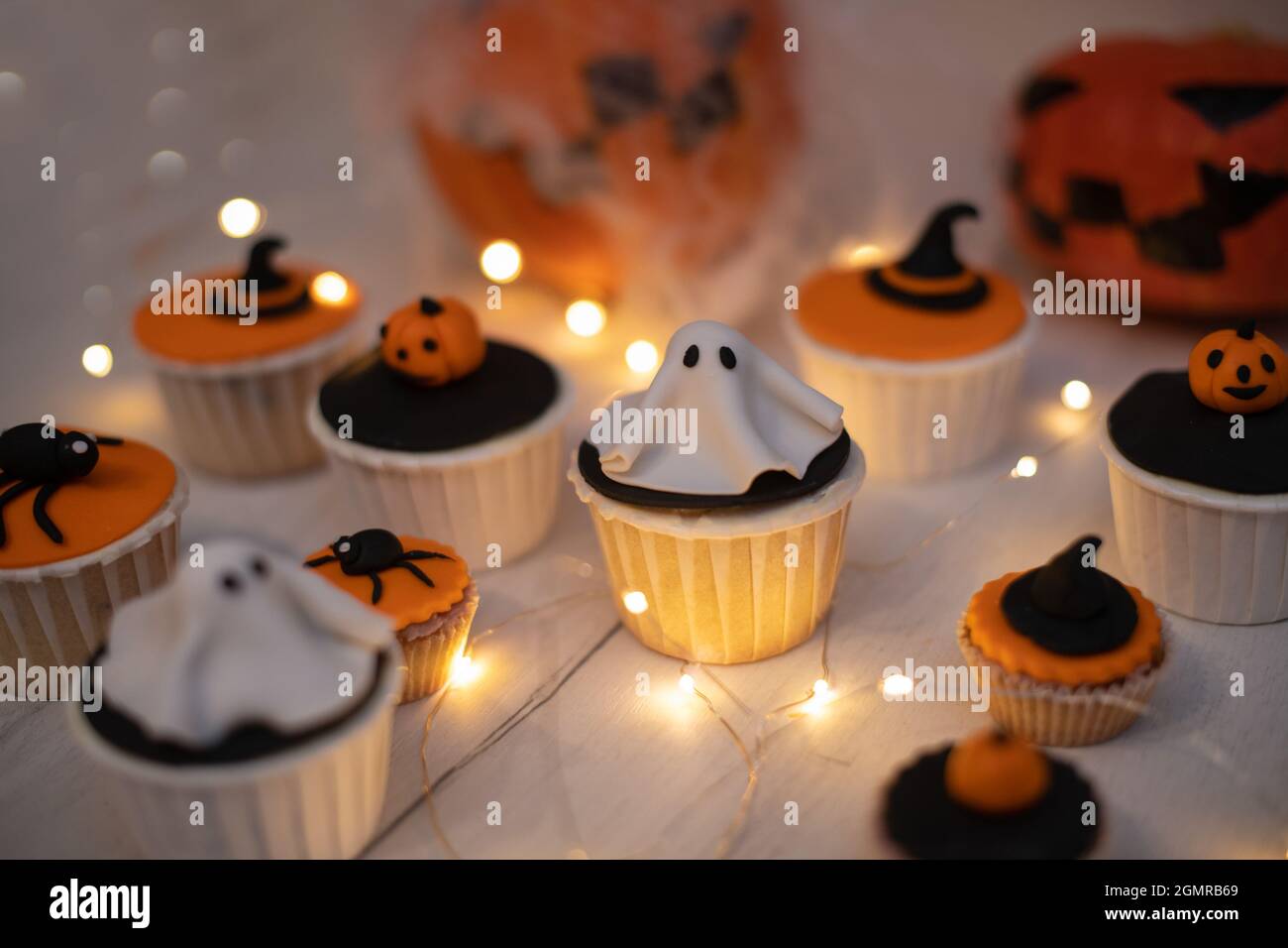 Muffin di Halloween con decorazioni in forma di fantasmi, zucche e cappelli di strega. Una serie di cupcake e dolci per una festa di Halloween. Foto Stock