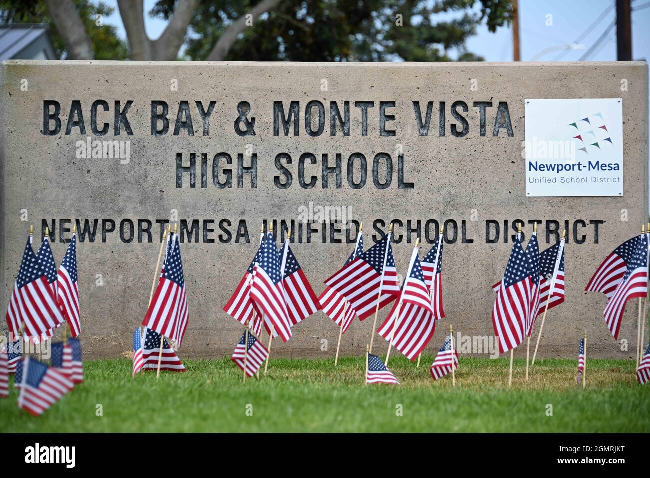 Piccole bandiere americane sono posti intorno alla segnaletica a Back Bay e Monte Vista High School, Martedì, Agosto 31, 2021, a Costa Mesa, Calif. Le bandiere erano p Foto Stock