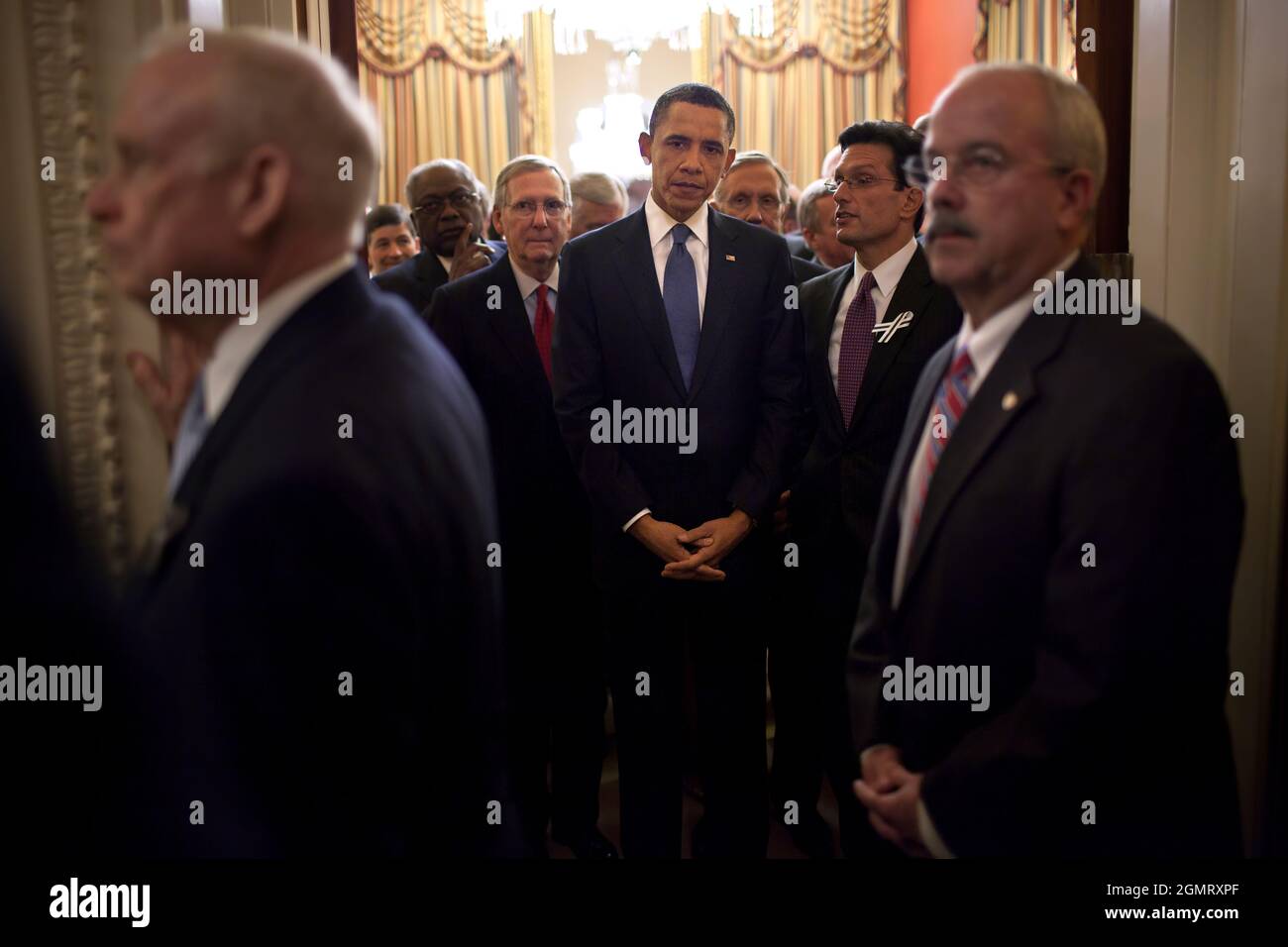 Il presidente Barack Obama si alza con i membri del Congresso in Camera Speaker John Boehner's cerimonial Office come Bill Livingood, House Sergeant at Arms, Left, e Terrance Gainer, Senato Sergeant at Arms, Right, preparano a scortarli sul pavimento della Camera presso il Campidoglio degli Stati Uniti, 25 gennaio 2011. (Foto ufficiale della Casa Bianca di Pete Souza) questa fotografia ufficiale della Casa Bianca è resa disponibile solo per la pubblicazione da parte delle organizzazioni di notizie e/o per uso personale la stampa dal soggetto(i) della fotografia. La fotografia non può essere manipolata in alcun modo e non può essere utilizzata in commercio Foto Stock