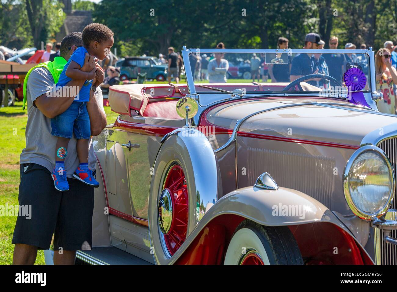 Grosse Pointe Shores, Michigan - un uomo tiene un ragazzo fino a vedere un roadster Studebaker 1931 agli occhi su Design auto show. La mostra di quest'anno è stata presentata da pri Foto Stock