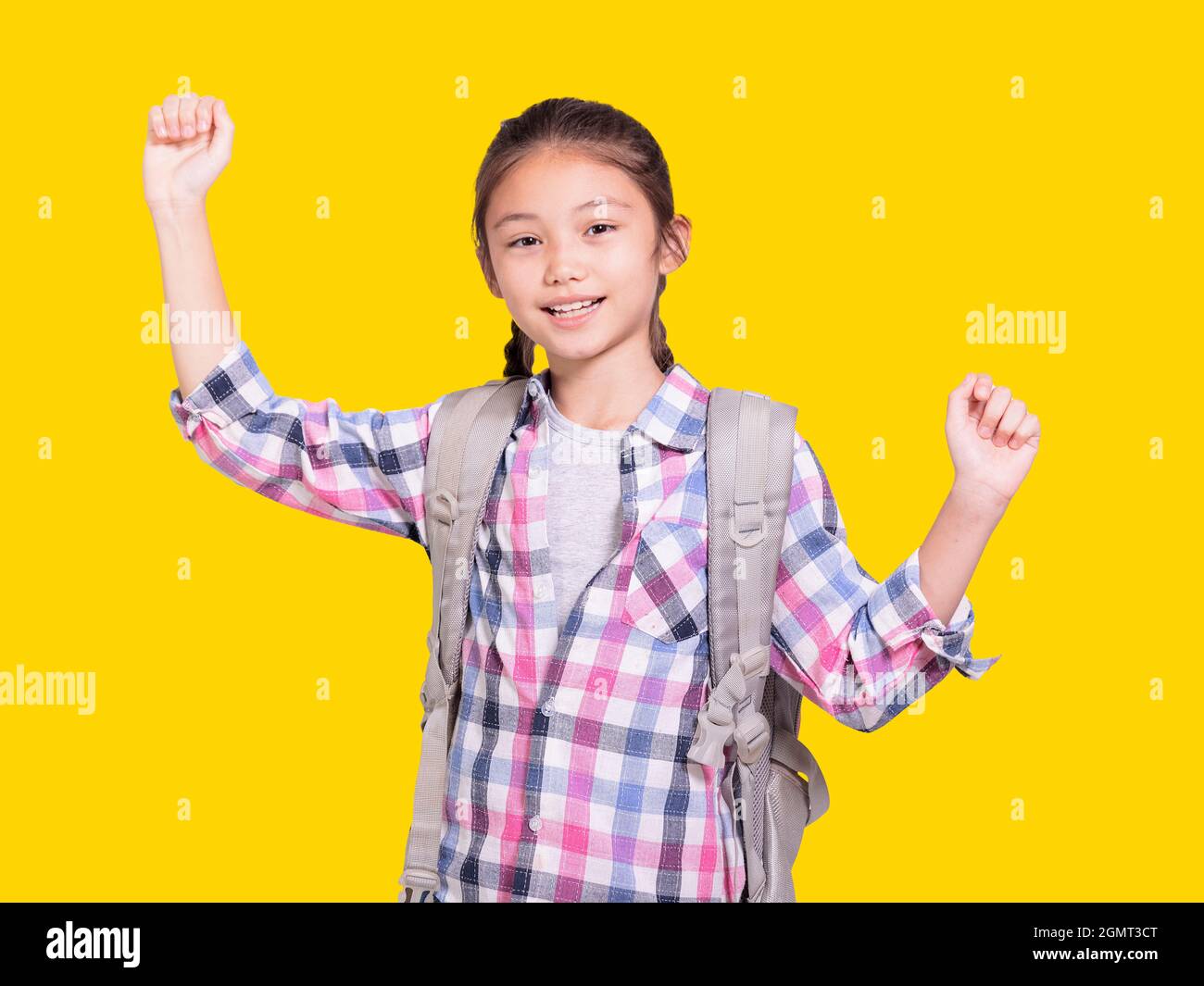 Ragazza felice studente con borsa scuola.Openning Arms.Isolated su sfondo giallo. Foto Stock