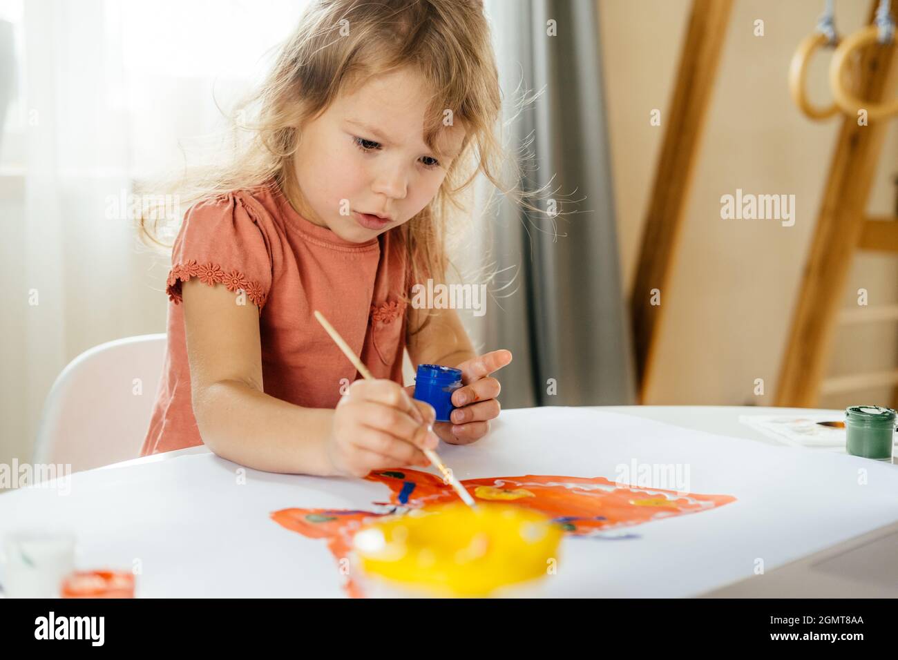 Bambina che trascorre un po' di tempo a disegnare utilizzando lezioni online su un notebook a casa. Apprendimento a distanza, formazione online. Foto Stock