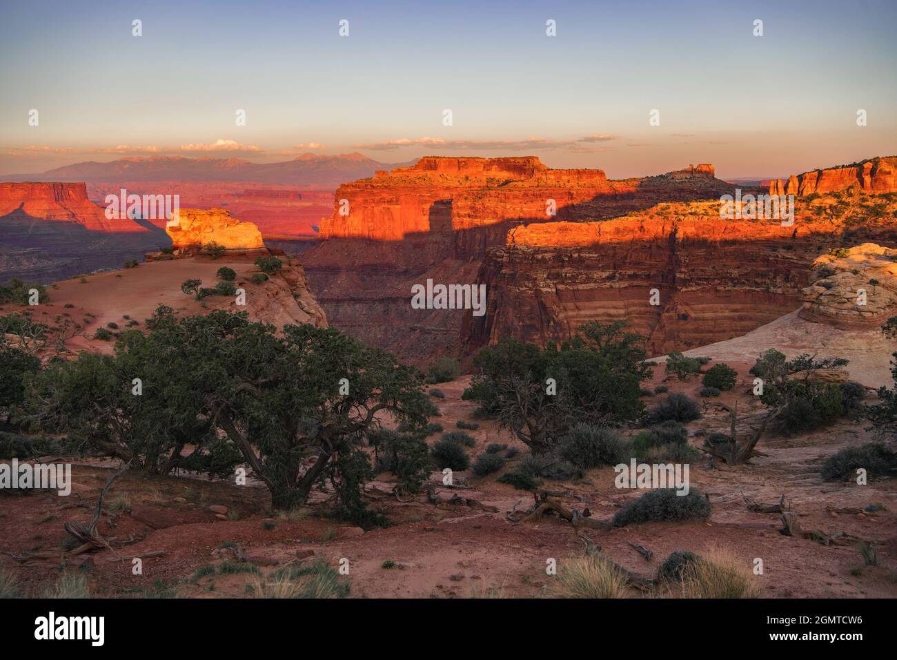 Tramonto panoramico nel Canyonlands state of Utah National Park. Paesaggio drammatico crudo coperto da luce solare rossastra. Foto Stock