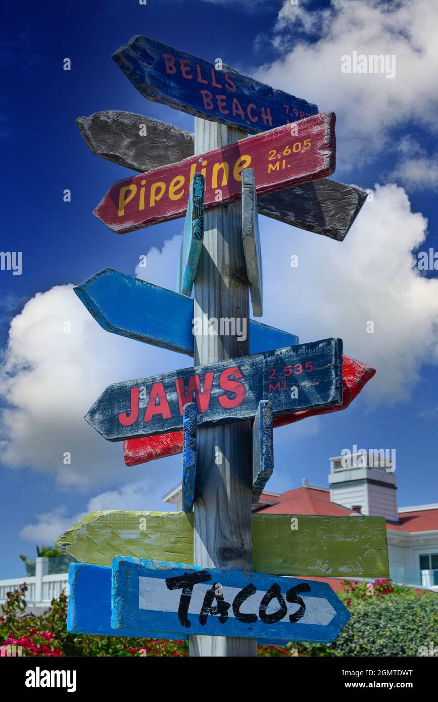 Un colorato cartello in legno con indicazioni direzionali sulla freccia della spiaggia con miglia, in stile iconico della cultura della spiaggia, nella California meridionale a Coronado Beach, S. Foto Stock