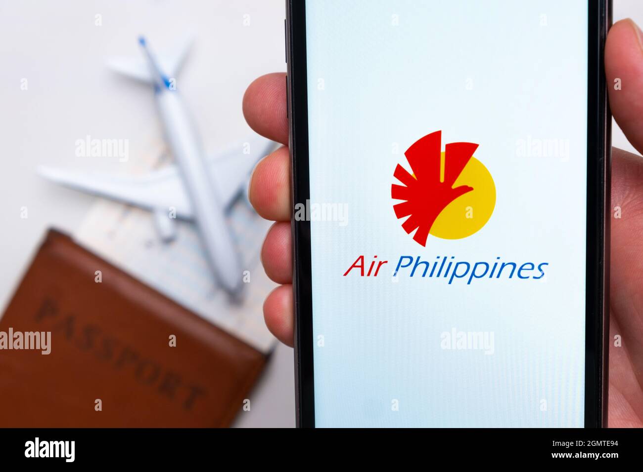 App o logo della compagnia Philippine Airlines visualizzati su un telefono cellulare con passaporto, carta d'imbarco e aereo sullo sfondo, settembre 2021, San Foto Stock