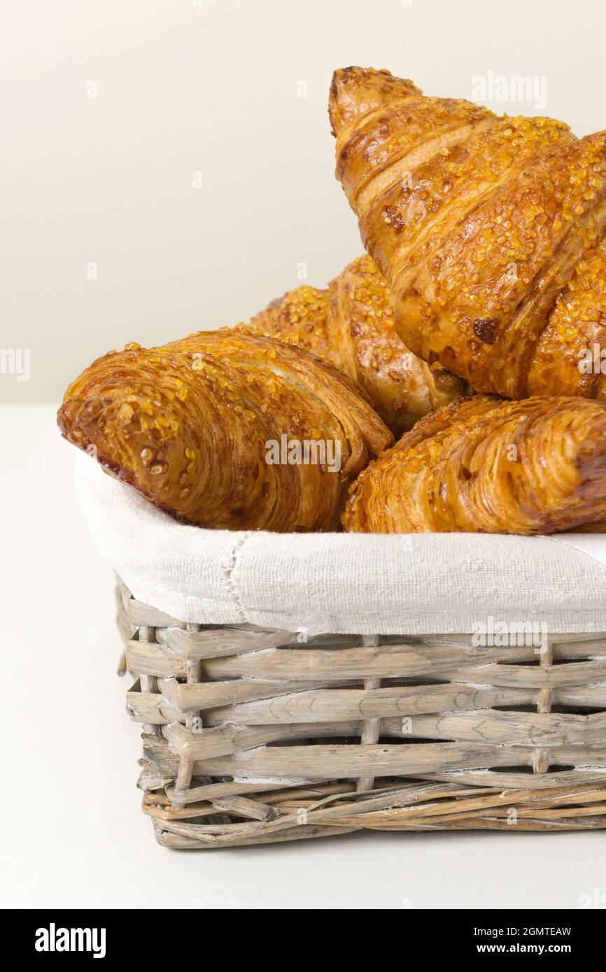 gustosi croissant nel cestino di vimini su sfondo bianco. Cucina francese. Primo piano Foto Stock