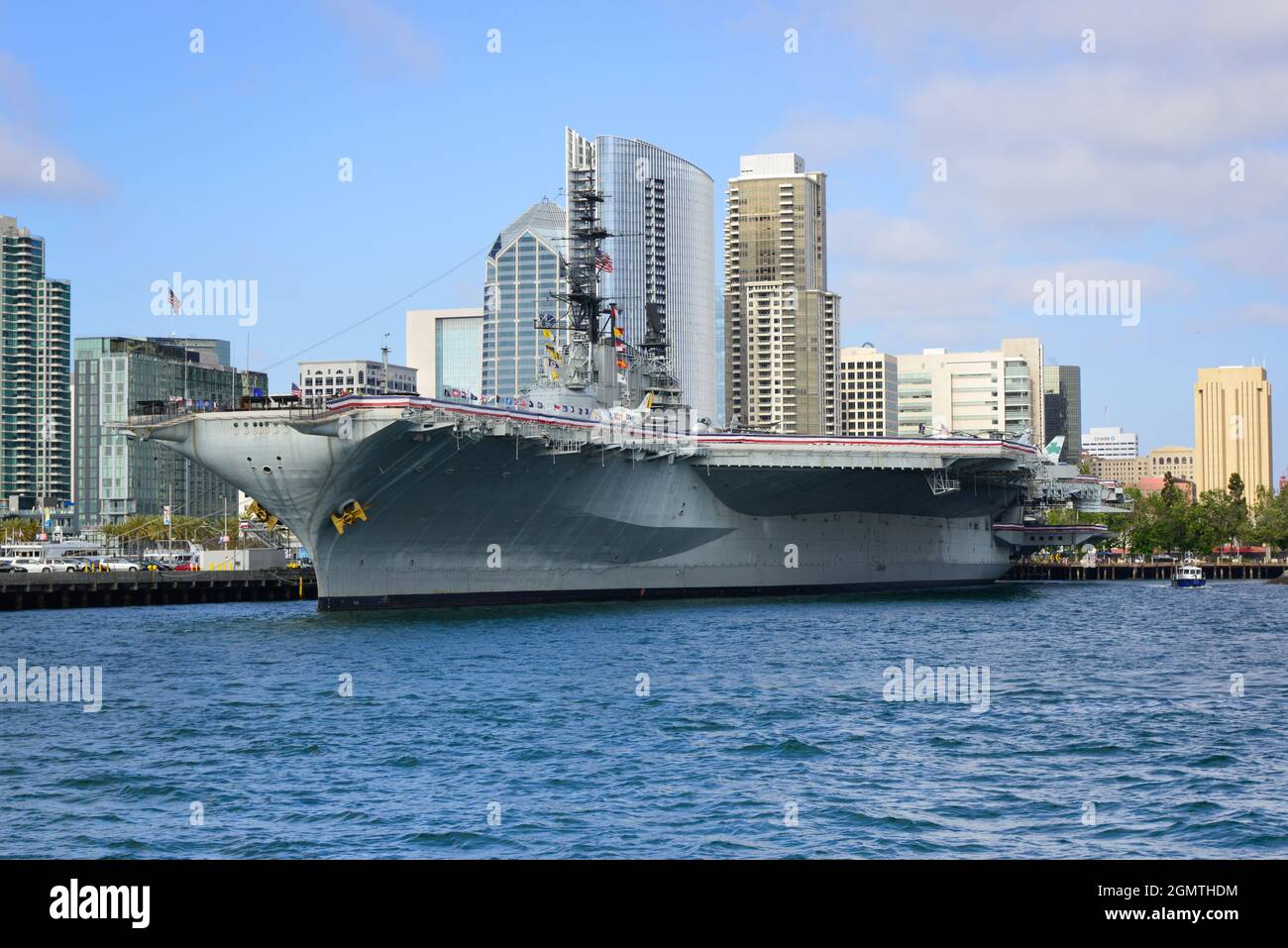 La USS Midway, la storica corazzata portaerei, ora museo, galleggia nel  porto di San Diego con lo skyline del centro in background, San Dieg Foto  stock - Alamy