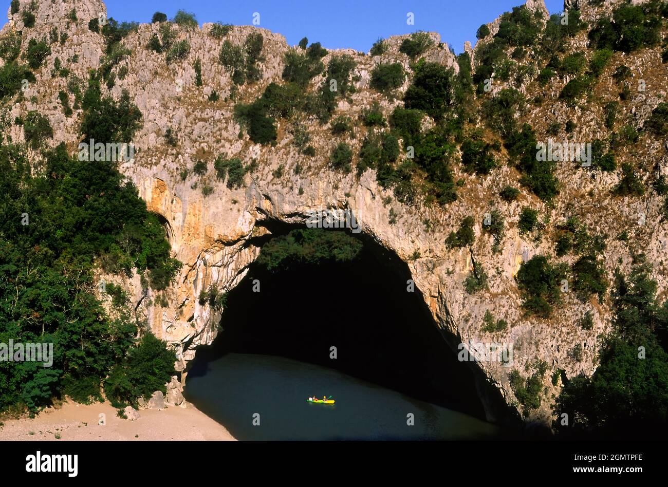 Ponte di pietra calcarea Pont d' Arc, Ardeche, Francia Francia - 20; due (piccole) persone in vista, canoa. Il Pont d'Arc è un grande ponte naturale calcareo ove Foto Stock