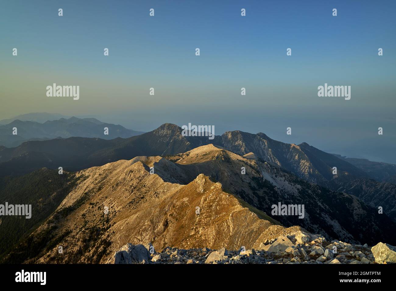 Vista della cresta verso il mare dalla cima della montagna Taygetos in Grecia con cielo blu chiaro poco dopo l'alba Foto Stock