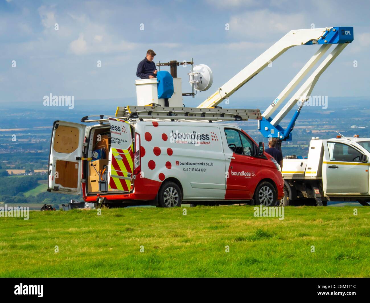 Tecnico delle telecomunicazioni che lavora su una connessione a banda larga in un sito collinare nel North Yorkshire Foto Stock