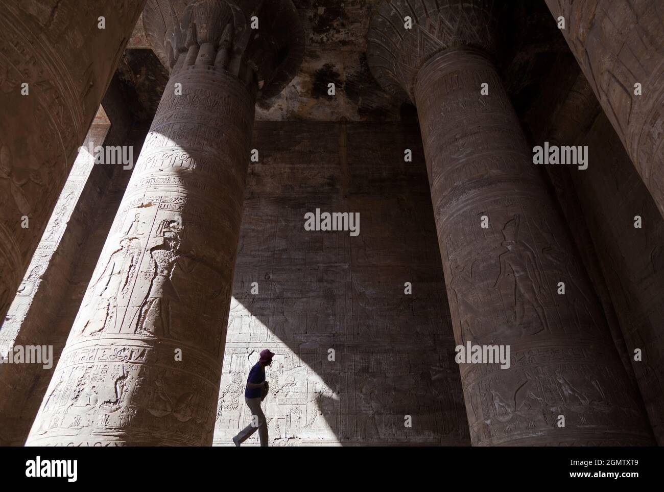 Edfu, Egitto - 1 Dicembre 2012 uomo all'ombra del Tempio di Edfu, Egitto. Questo bellissimo tempio, immacolato e conservato, dedicato al falco Foto Stock