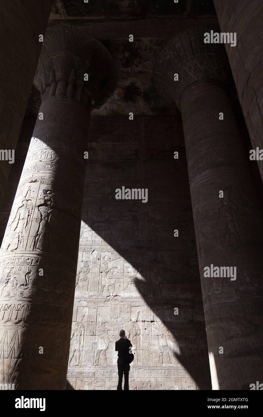Edfu, Egitto - 1 Dicembre 2012 Donna all'ombra del Tempio di Edfu, Egitto. Questo bellissimo tempio, immacolato e conservato, dedicato al falco Foto Stock