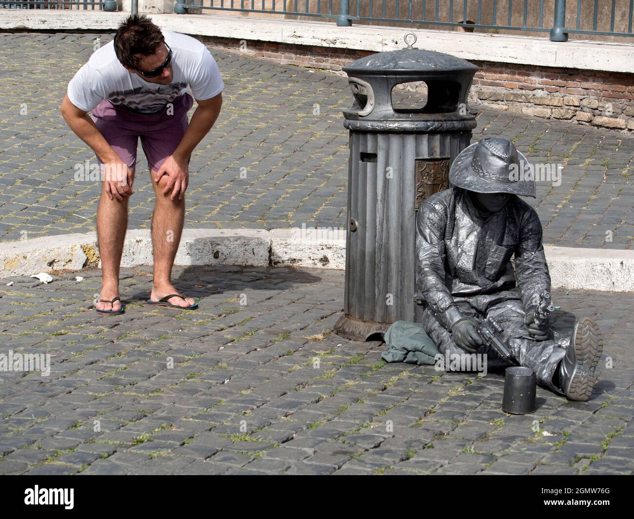 Roma, Italia - 21 ottobre 2014 Un passante ispeziona un artista di strada statico del Ponte Sant'Angelo di Roma. Foto Stock