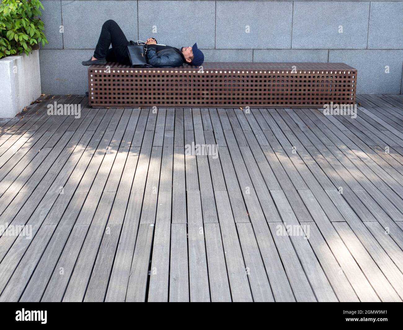 Marina Bay, Singapore - 4 marzo 2019; un uomo che dorme a colpo. Marina Bay nel centro di Singapore City è stato ampiamente riprogettato e mod Foto Stock