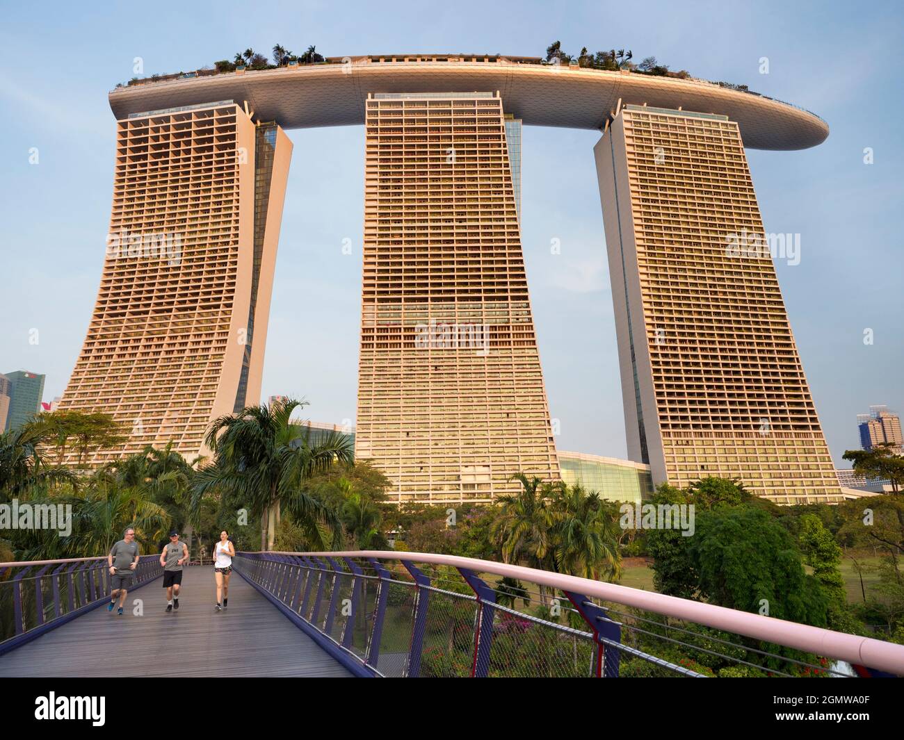 Gardens by the Bay, Singapore - 3 - 5 Marzo 2019; tre jogger in shot. L'iconico Marina Bay Sands Hotel, inaugurato nel 2010, è un hotel lussuoso Foto Stock