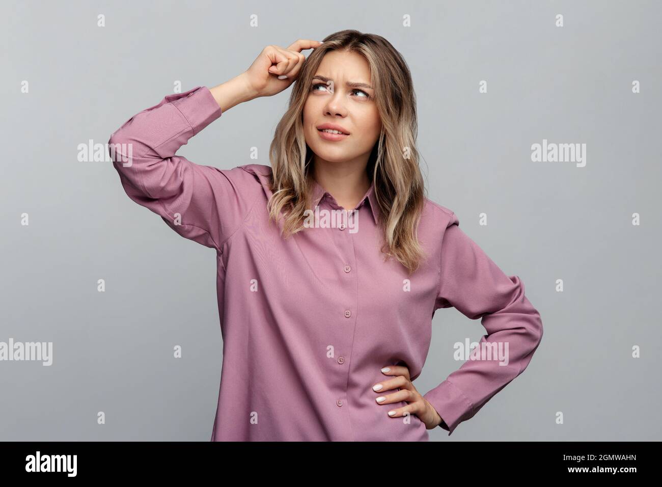 Dubbioso scettico donna grumpy guardare in su toccando testa pensando a una decisione importante con scetticismo Foto Stock