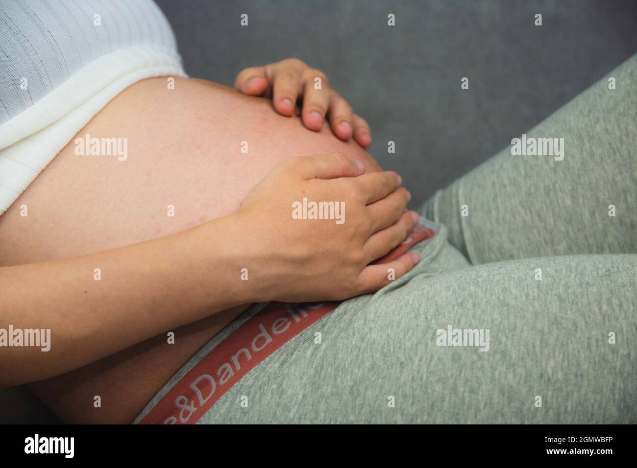 Donna incinta mentre tiene il suo stomaco Foto Stock