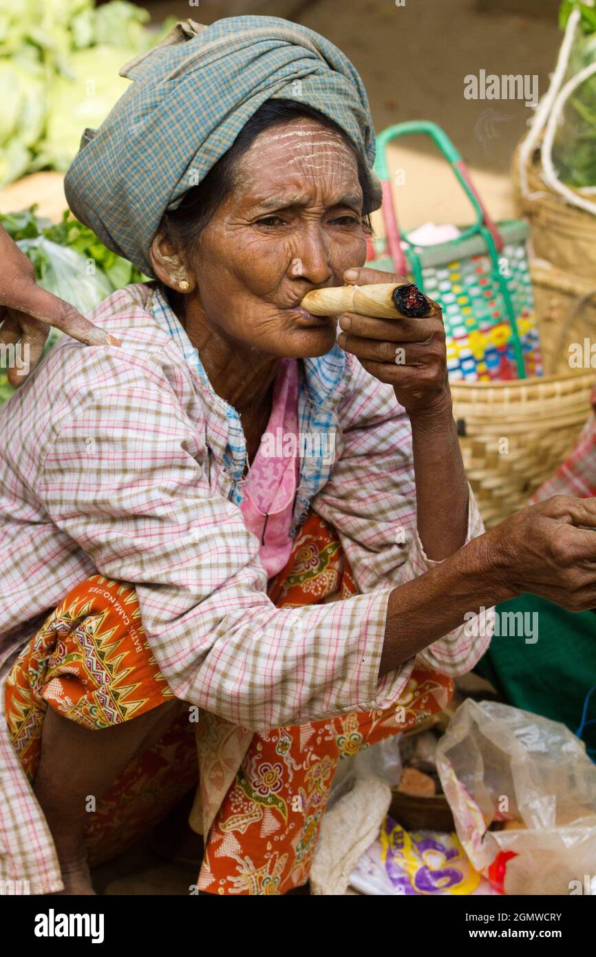 Bagan, Myanmar - 28 gennaio 2013; una donna anziana in colpo. Vecchia donna tribale che fuma un sigaro fatto in casa e arrotolato a mano in Nyaung - U Market Foto Stock