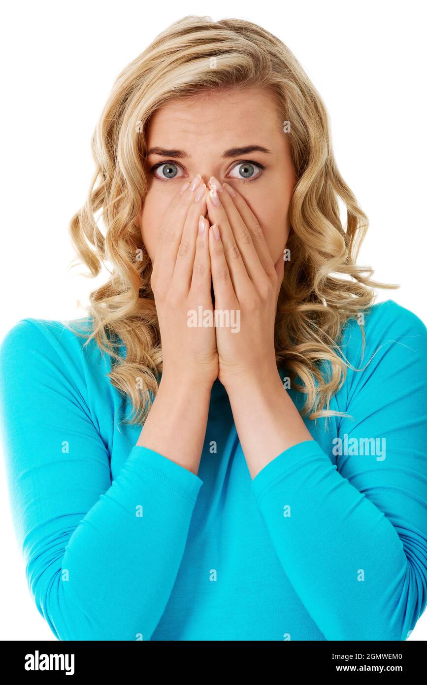 Scioccata donna polacca in abiti blu coprendo la bocca isolato su sfondo bianco Foto Stock