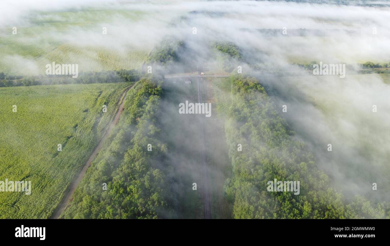 Intersezione di ferrovie e autostrada. Vista da un'altezza sopra la nebbia d'autunno mattina Foto Stock