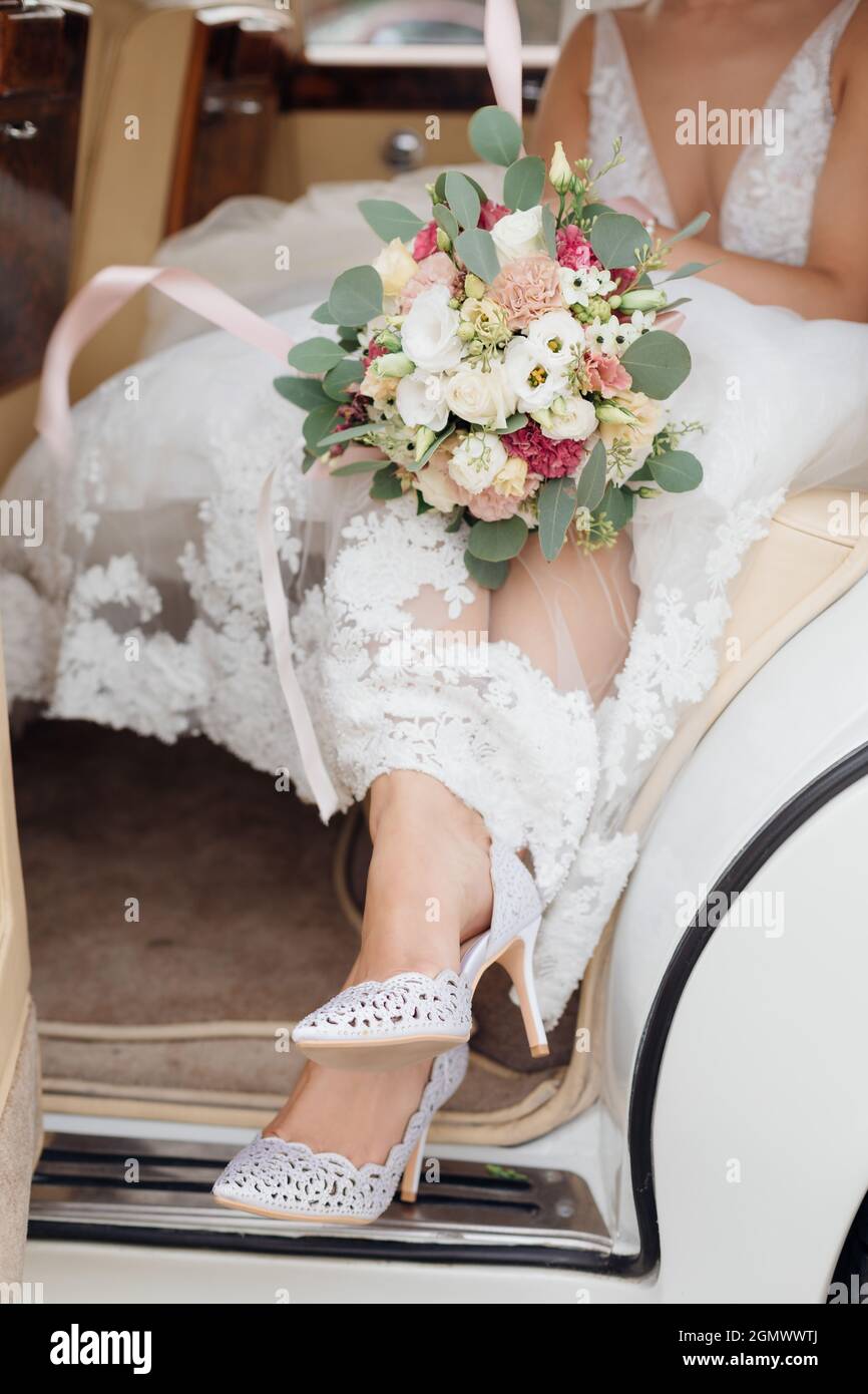 Bride piedi in scarpe da matrimonio in porta auto aperta. Concetto di  dettagli di matrimonio, celebrazione, persone irriconoscibili. Foto di alta  qualità Foto stock - Alamy