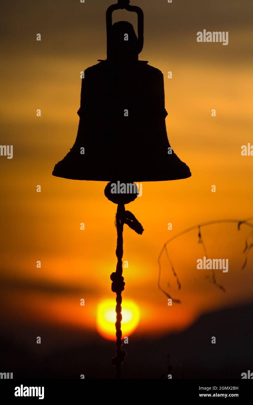 Dambulla, Sri Lanka - 9 febbraio 2014 c'è qualcosa di estremamente suggestivo su una campana che si fa a pedaggio al tramonto, alla morte del giorno... Foto Stock