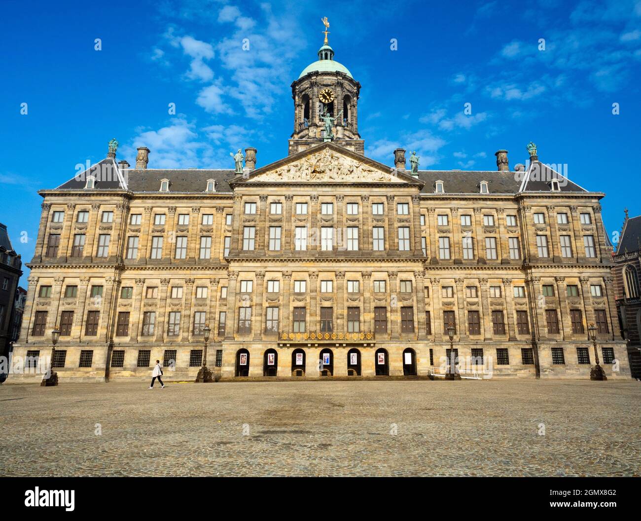 Amsterdam, Paesi Bassi - 27 maggio 2016; una persona in vista, passeggiando. Il Palazzo reale di Amsterdam è stato costruito come municipio durante l'oro olandese Foto Stock