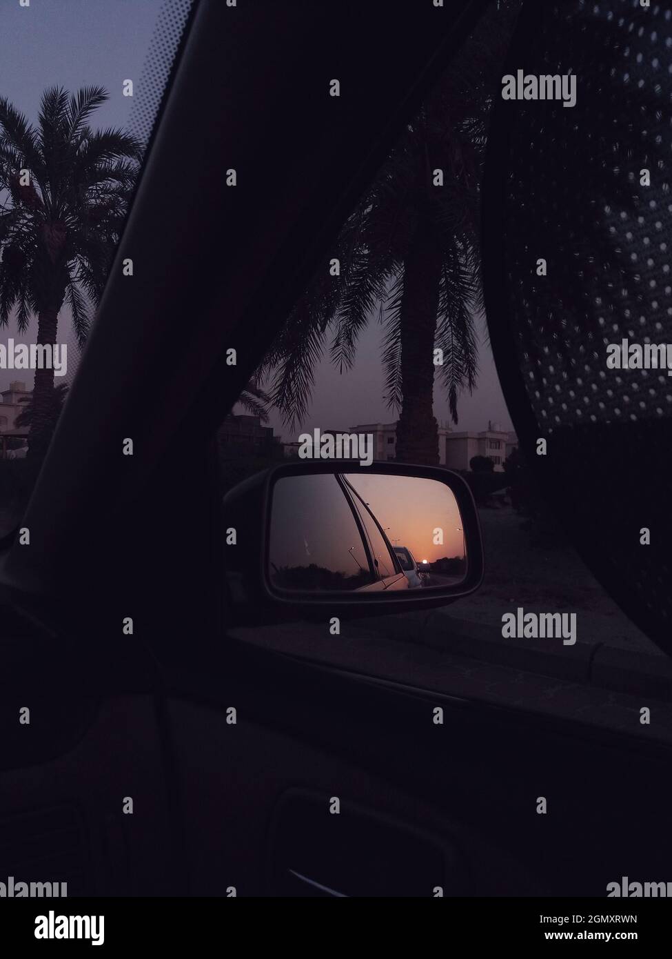 Vista al tramonto attraverso lo specchietto retrovisore lato auto. Bellissima ora del tramonto. Foto Stock